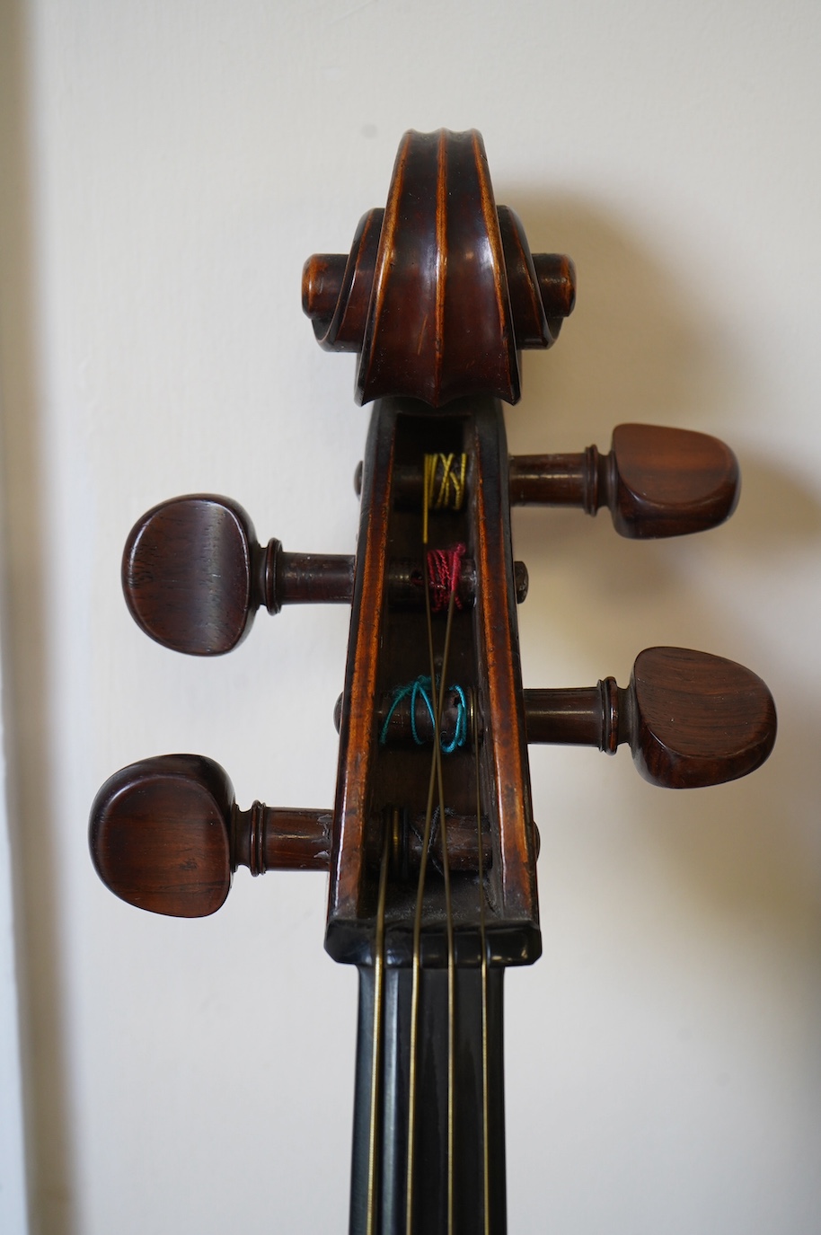 An early 19th century cello with a Stradivarius label, body 76cm, with a P&H bow, in a good modern case. Condition - poor